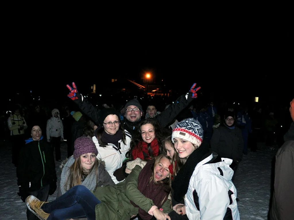 Jugendliche posieren abends ausgelassen für ein Foto.